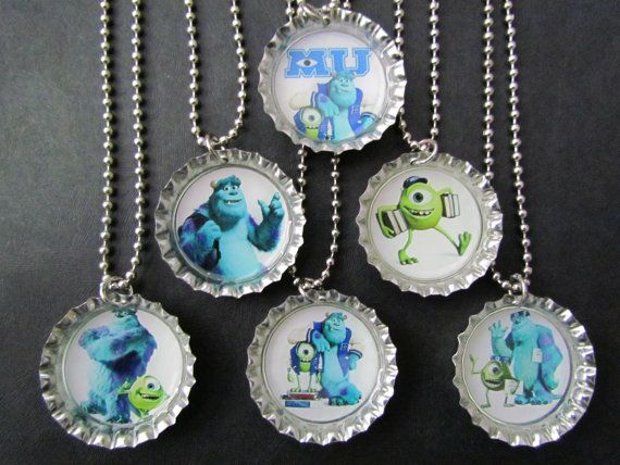 six bottle caps with images of monsters on them hanging from a silver ball chain necklace