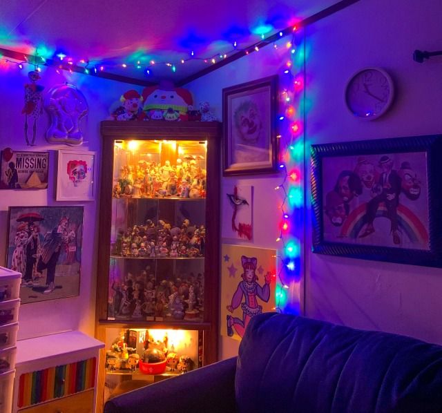 a living room filled with lots of toys and lights on the wall next to a couch