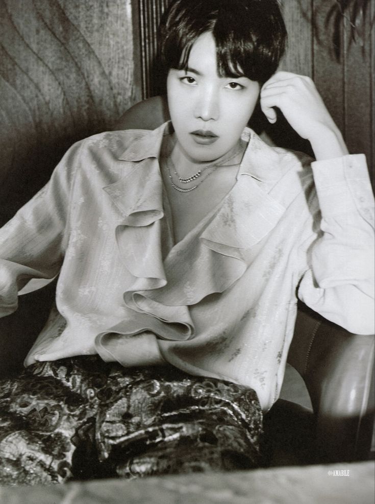 black and white photograph of a woman sitting in a chair with her hand on her head