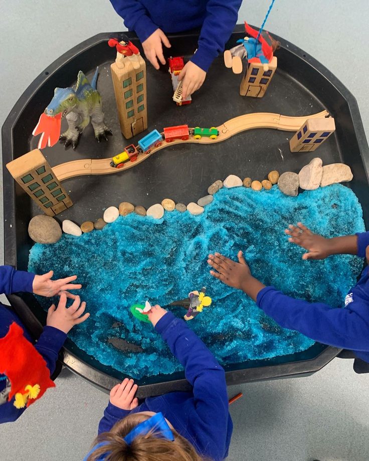 three children are playing with toys on a table