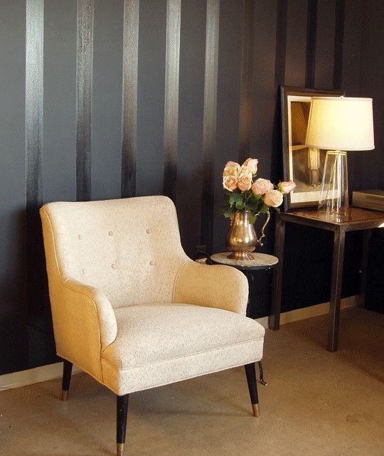 a chair and table in a room with striped walls