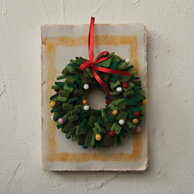 a small christmas wreath hanging on the wall