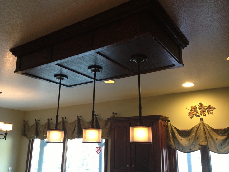 three lights are hanging from the ceiling in this kitchen