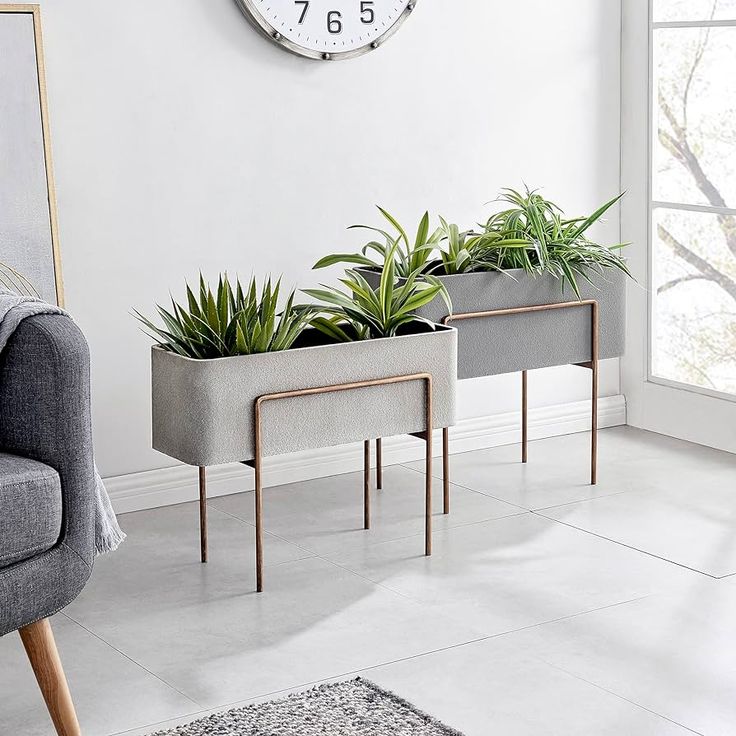 two planters sitting next to each other in front of a clock