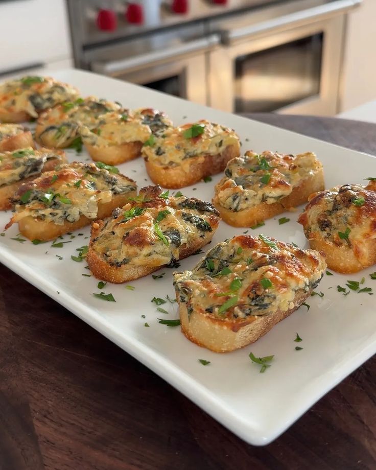 small appetizers are arranged on a white platter in front of an oven