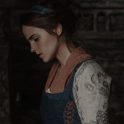 a woman in an old fashioned dress looking down