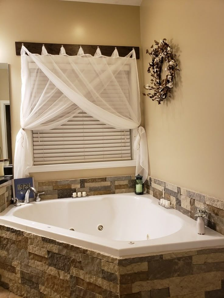 a large white bath tub sitting under a window