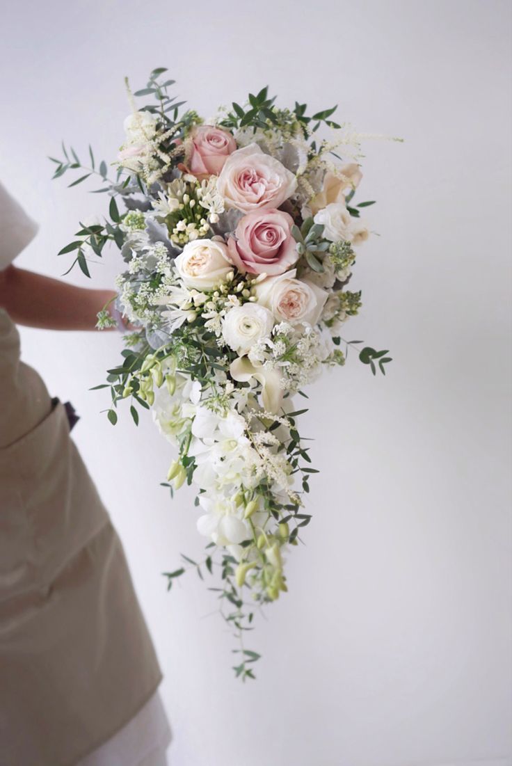 a bridal holding a bouquet of white and pink flowers