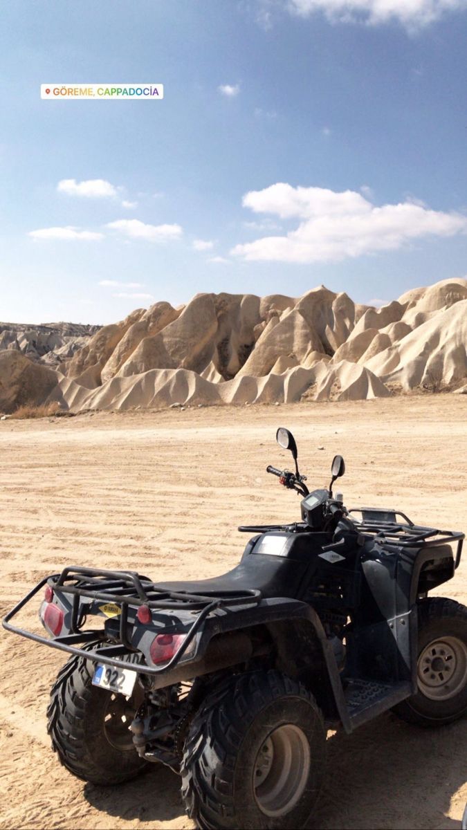 two atvs parked in the desert with mountains in the background