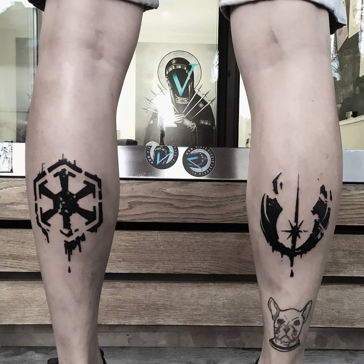 two people with tattoos on their legs standing next to each other