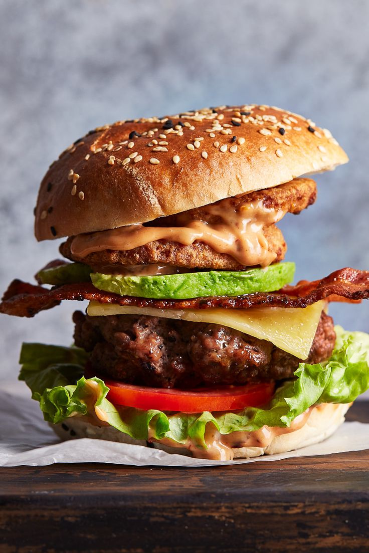 a hamburger with bacon, lettuce and tomato