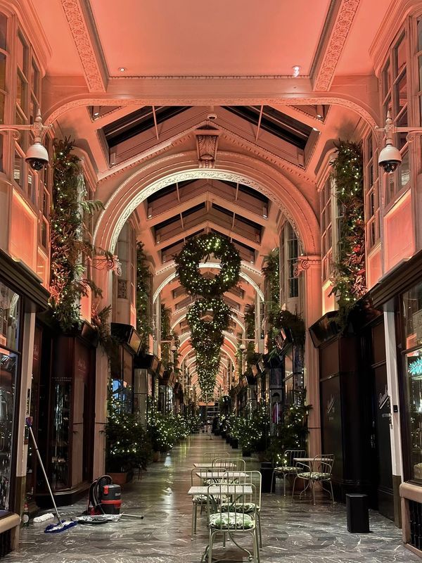 an empty shopping mall with christmas decorations hanging from the ceiling