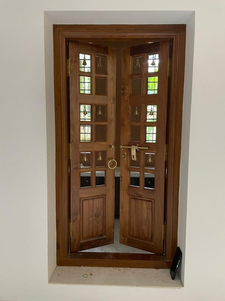 an open wooden door with two sidelights and glass inserts on the top half