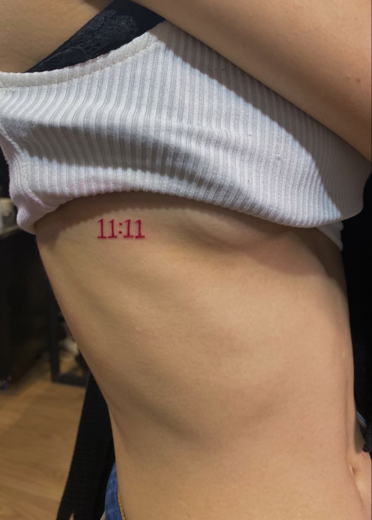 a woman's stomach with the word 11 11 written on her lower side and bottom