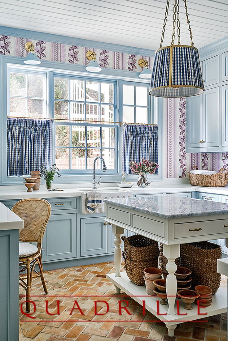 a kitchen with blue cabinets and tile flooring next to a large island in the middle of the room