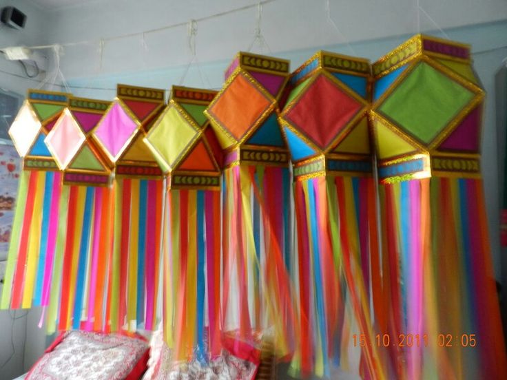 there are many colorful curtains hanging from the ceiling in this room with pillows on it