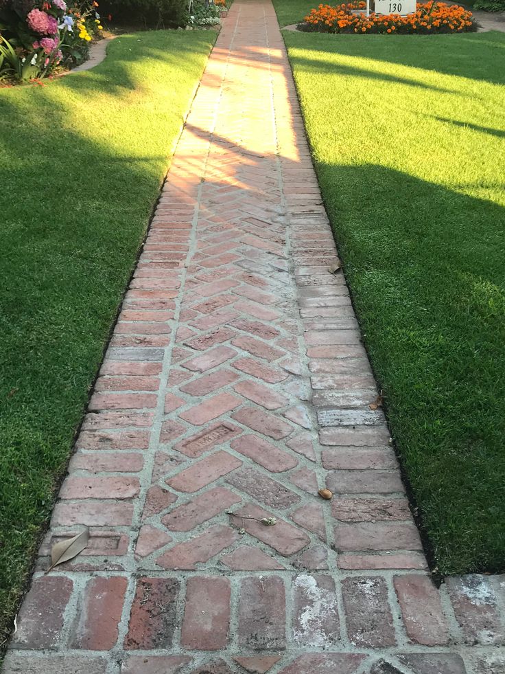 a brick walkway in front of a house