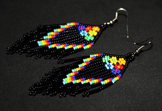 a pair of black earrings with multicolored beads hanging from it's hooks