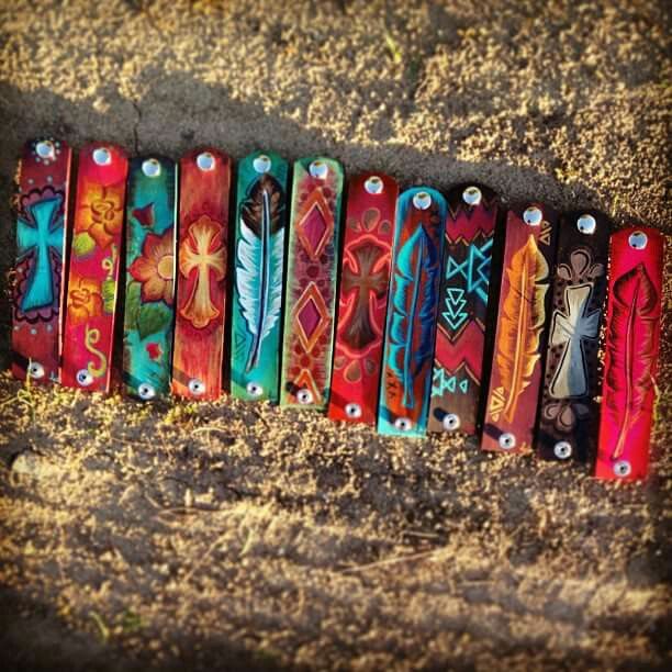 a row of colorful bracelets sitting on top of dirt covered ground next to each other