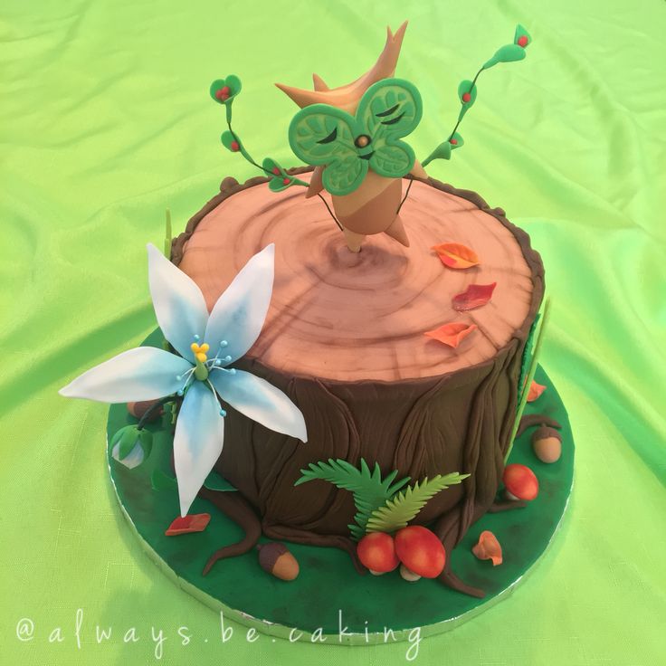 there is a cake that looks like a tree stump with an owl on top and flowers in the middle