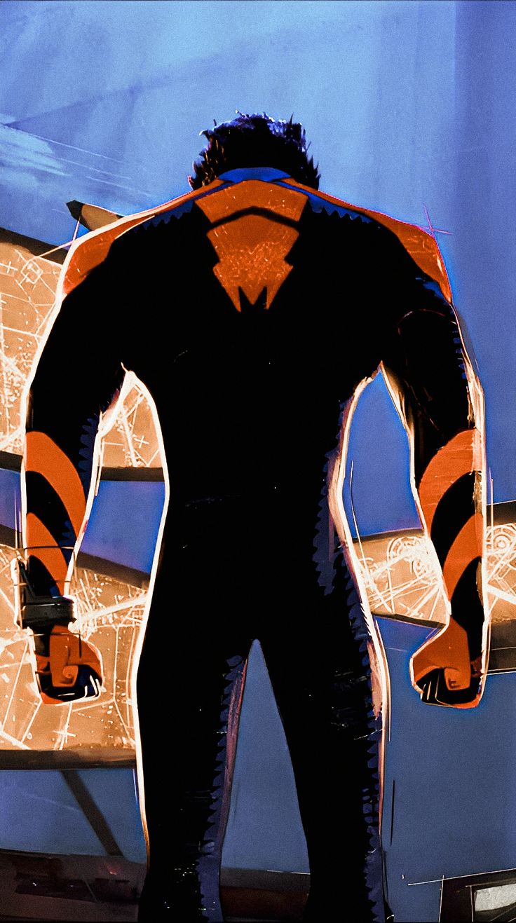 a man in a black and orange suit standing next to a surfboard