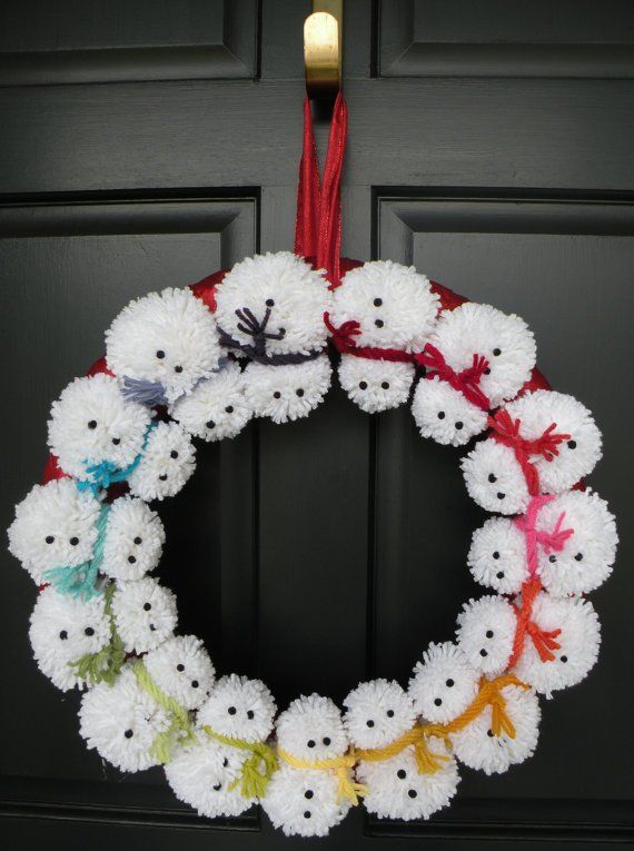 a knitted wreath hanging on a door with the words, 100 ideas about pom pom wreath on pinterest