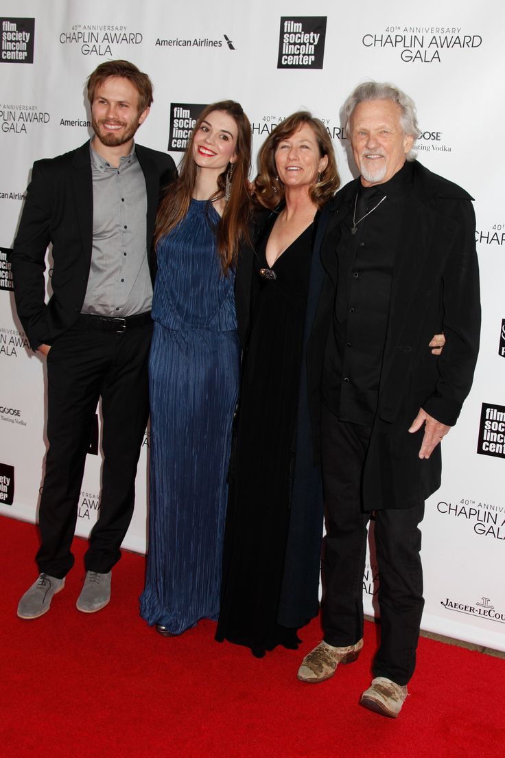 three people standing next to each other on a red carpet