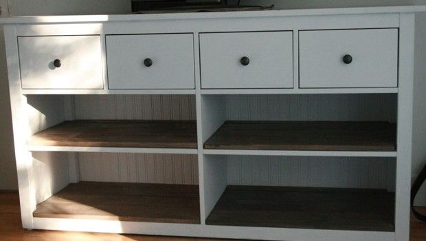 a white entertainment center with drawers and a flat screen tv