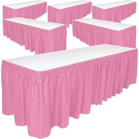 six pink tables with white covers on them