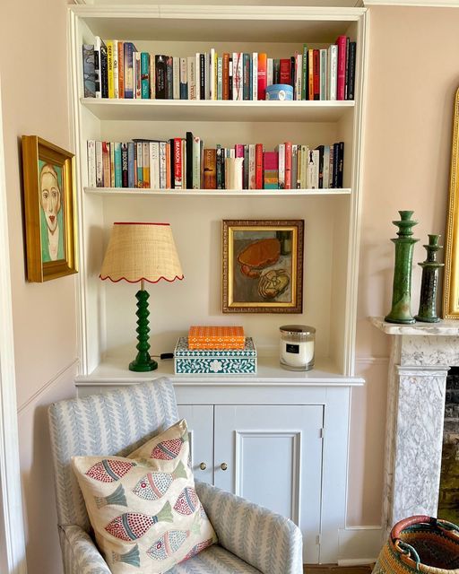 a living room filled with furniture and bookshelves next to a white fire place