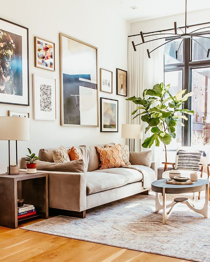 a living room filled with furniture and lots of pictures on the wall above it's windows