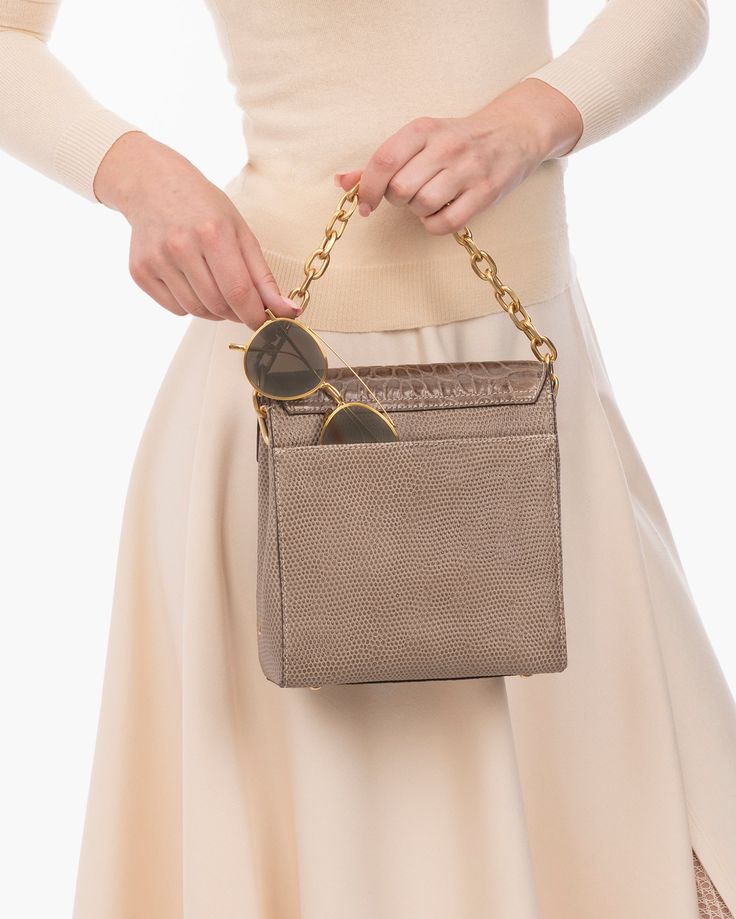 A compact, semi-structured flap pouch of embossed calf leather holds more than you realize and takes you seamlessly from day into evening. Multiple handle options make Livia one of the most versatile women's crossbody bags for sale online. The faceted gold-tone chain link top handle either dangles as ornamentation when the crossbody strap is in use, or if you prefer, detaches altogether. The long leather strap adjusts from shoulder to crossbody length by use of a belt buckle. Outer pocket on rev Luxury Flap Bag With Chain Strap For Daily Use, Trendy Bags With Gold-tone Hardware For Everyday Luxury, Luxury Crossbody Box Bag With Chain Strap, Elegant Gold Flap Bag With Chain Strap, Everyday Luxury Gold Rectangular Flap Bag, Gold Top Handle Flap Bag With Gold-tone Hardware, Modern Gold Flap Bag With Gold-tone Hardware, Gold Flap Bag With Top Handle And Gold-tone Hardware, Gold Rectangular Flap Bag For Everyday Luxury