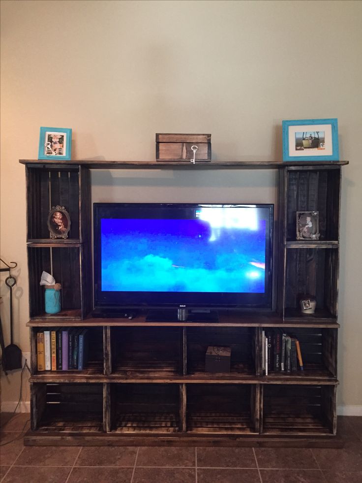 an entertainment center with a flat screen tv on it's stand, and bookshelves