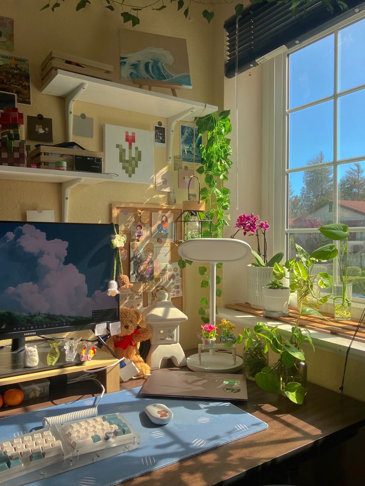 a desk with a computer monitor on top of it next to a potted plant