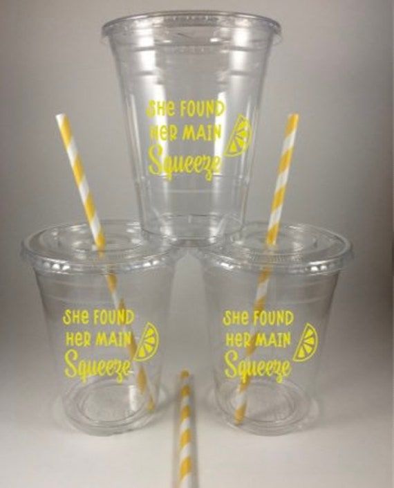 four plastic cups with yellow and white striped straws in the bottom one is empty