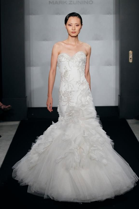 a woman in a white wedding dress walking down the runway at mark zunino