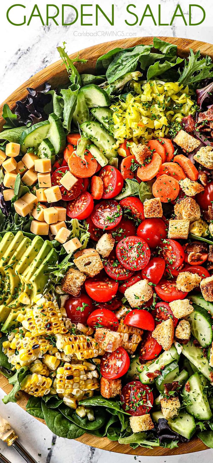 a large salad with tomatoes, cucumber, lettuce and other vegetables