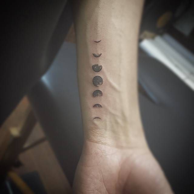 a person's arm with three phases of the moon on it