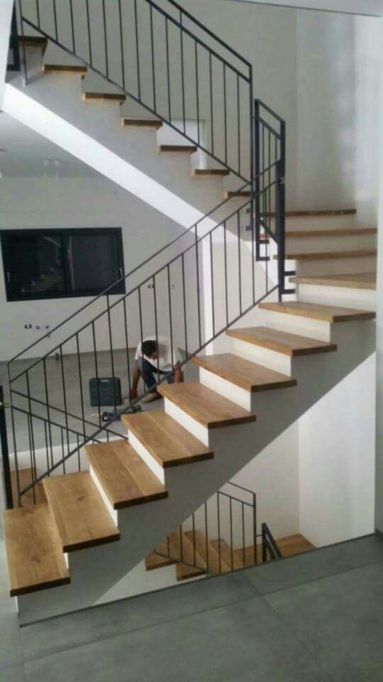 there is a man sitting on the stairs in front of some stairs with wood treads