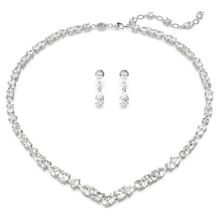 Exquisite refinement is brought to life in this show-stopping jewelry set from the Mesmera family. The necklace is made with a string of eye-catching Swarovski Zirconia on a rhodium plating setting, all produced in a surprising mix of cuts and sizes. For extra luxury, the elongation is completed with a lobster closure and a scattering of Swarovski Zirconia. The light-catching earrings are also rhodium plated, with a bold hanging design featuring luminous pear-cut crystals. Gift this set to a lov Swarovski Necklace Crystal, Swarovski Jewelry Set, Swarovski Jewelry Aesthetic, White Gold Jewelry Set, Swarovski Jewelry Necklace, Bride Jewelry Set, Luxurious Jewelry, Necklace Luxury, Hanging Design