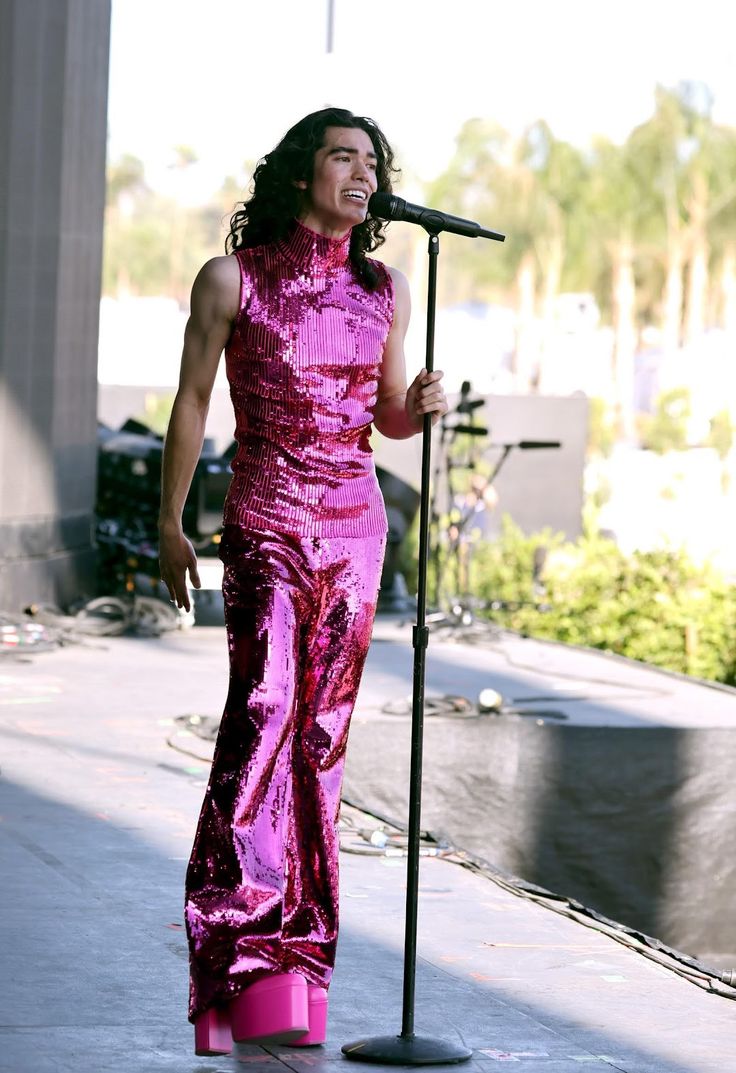 a woman in pink is singing into a microphone