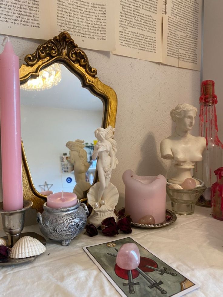 a table topped with candles next to a mirror and other items on top of it