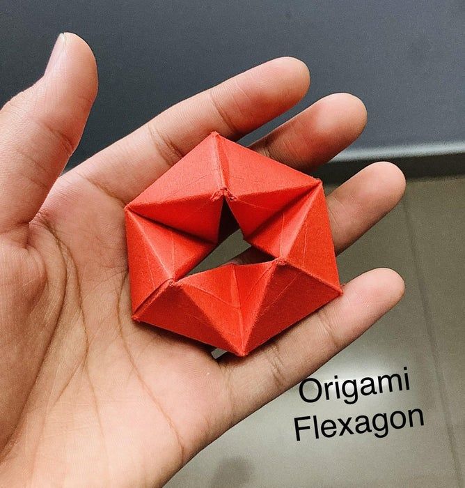 a hand holding an origami piece in it's palm