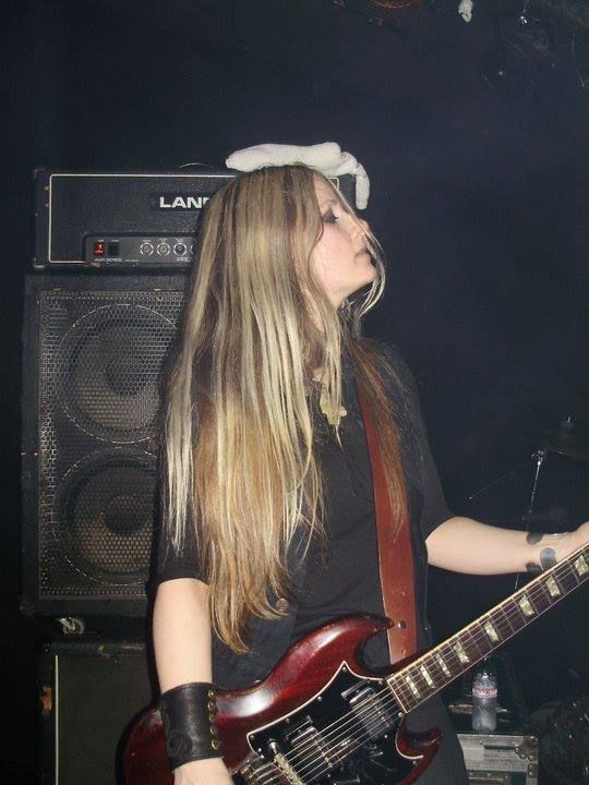 a woman with long hair playing an electric guitar