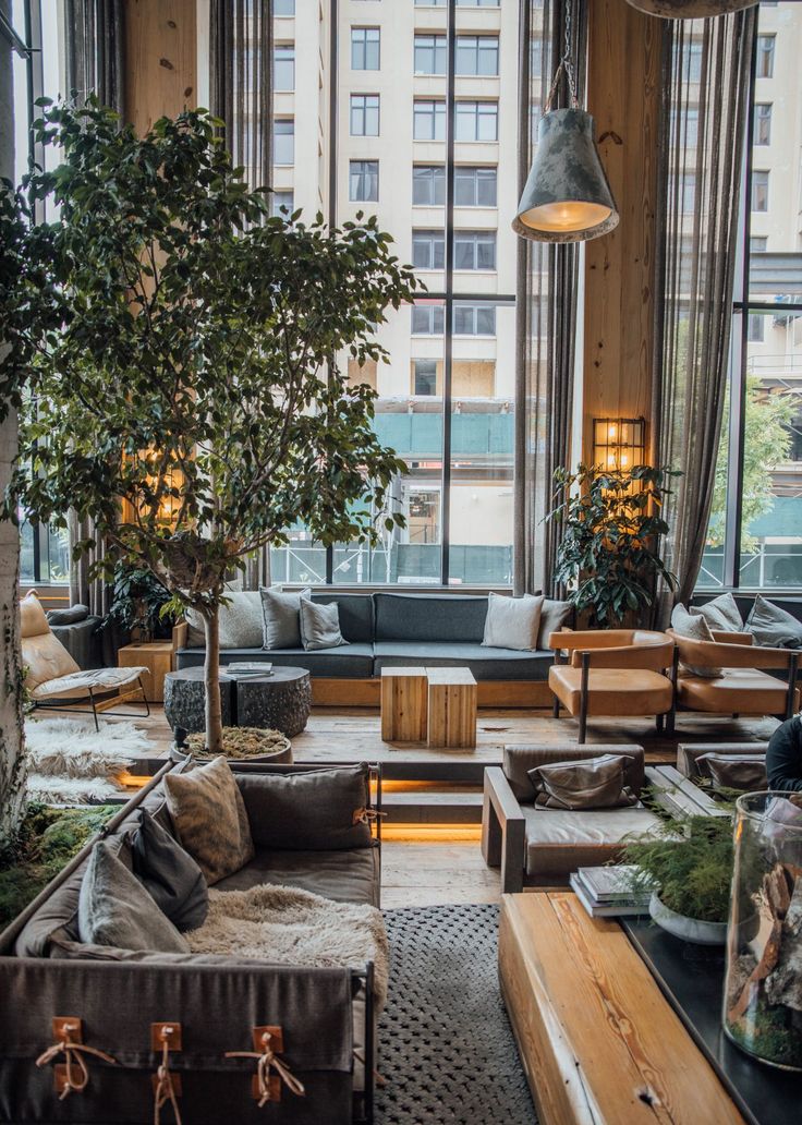 a living room filled with lots of furniture and a tree in the middle of it