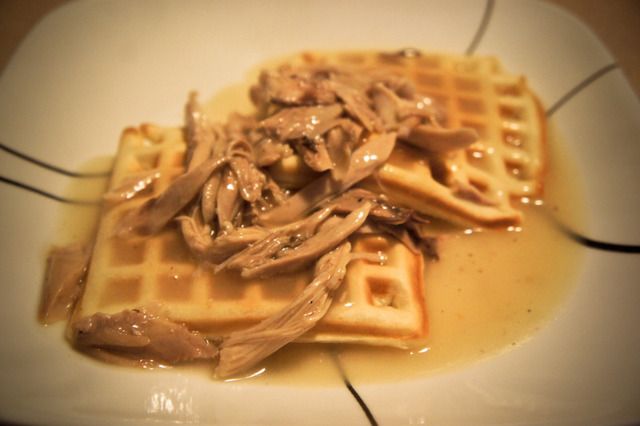 a waffle topped with meat and gravy on top of a white plate