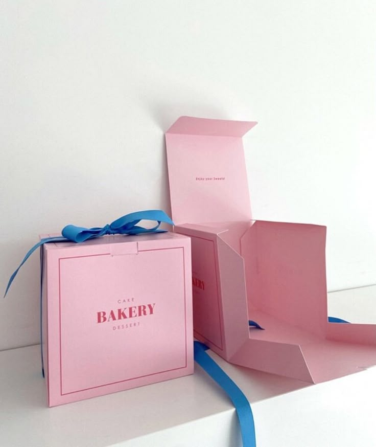 an open pink box with a blue ribbon