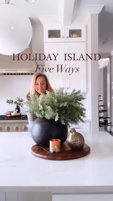 a woman standing behind a large potted plant on top of a white countertop