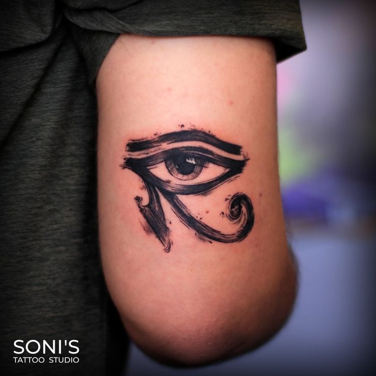 an all seeing eye tattoo on the left side of the right arm is shown in black ink