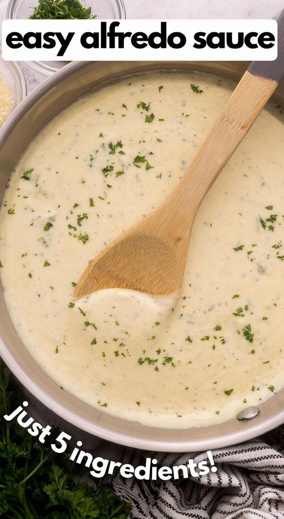 a wooden spoon in a pot filled with cheese sauce